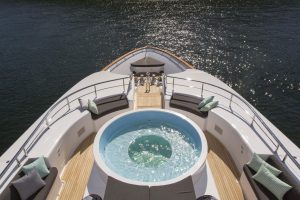Watch race day preparations from the hot tub on the deck of a superyacht.