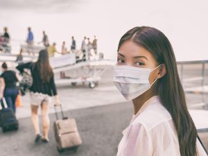 Woman With Face Mask Boards Plane