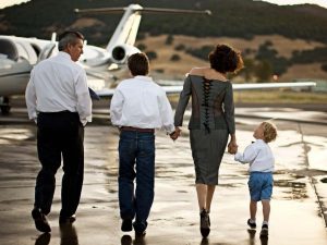 alt="Young family walking toward a private jet"